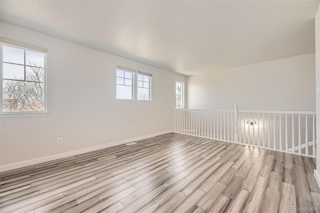 empty room featuring light wood-style flooring and baseboards