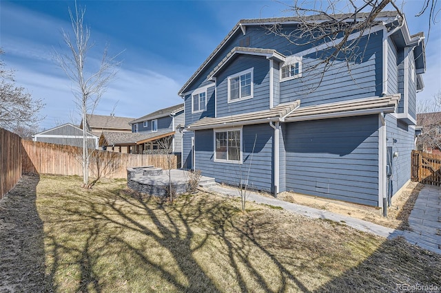 back of house featuring a lawn and a fenced backyard