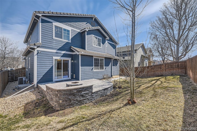 rear view of property featuring a fenced backyard, a lawn, central AC, and a patio