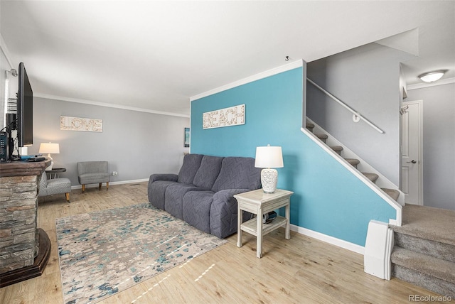 living room with wood finished floors, crown molding, and stairs