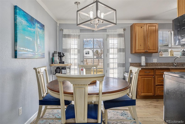 dining room with a chandelier, a textured wall, baseboards, ornamental molding, and light wood-type flooring