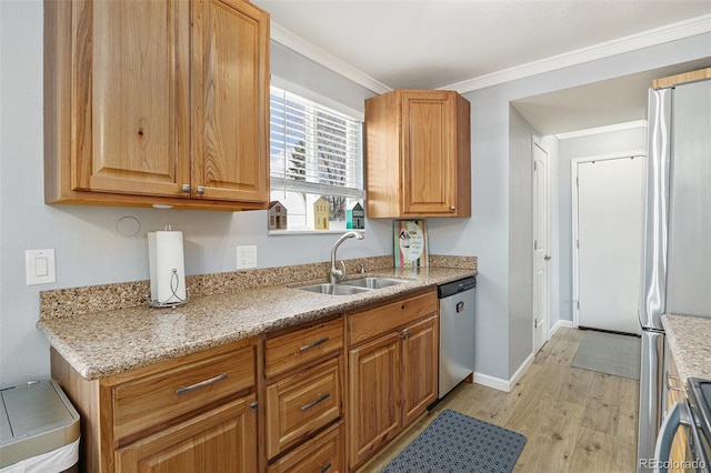 kitchen with baseboards, stainless steel appliances, crown molding, light wood-type flooring, and a sink