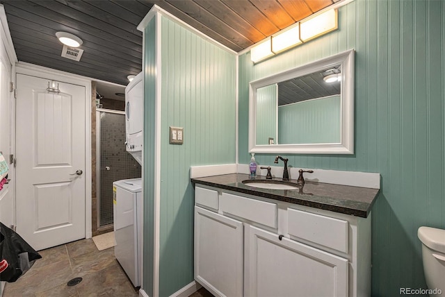 full bath featuring visible vents, vanity, wood ceiling, stacked washing maching and dryer, and a shower stall