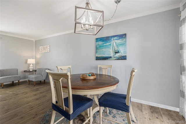 dining room with baseboards, wood finished floors, and crown molding