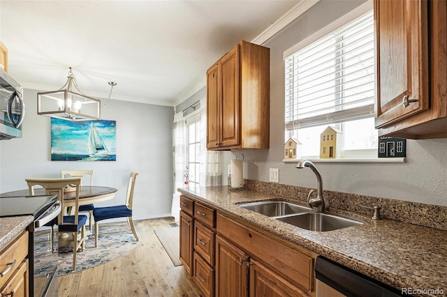 kitchen with stainless steel appliances, ornamental molding, brown cabinetry, and a sink