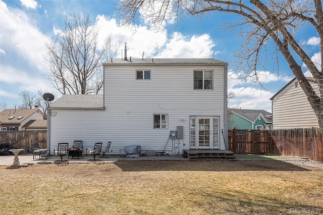 rear view of property with a fire pit, a yard, a patio area, and a fenced backyard