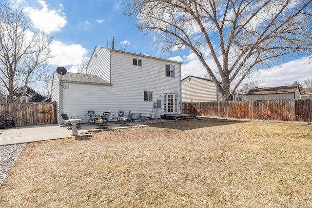 rear view of house featuring a patio area, fence, and a lawn