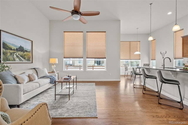 living room with sink, hardwood / wood-style flooring, and ceiling fan