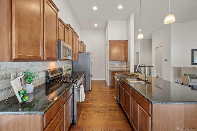 kitchen with sink, pendant lighting, appliances with stainless steel finishes, and tasteful backsplash