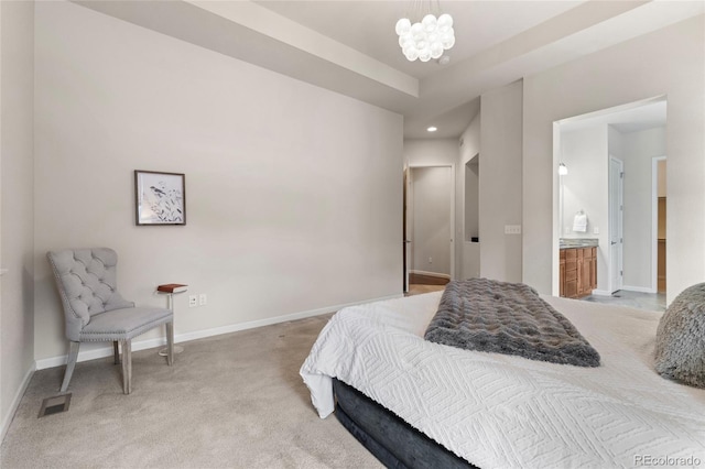 carpeted bedroom with a chandelier and ensuite bathroom