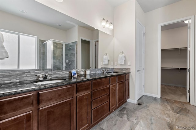 bathroom featuring vanity, decorative backsplash, and an enclosed shower