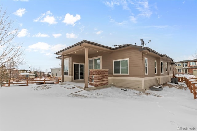 snow covered property featuring central AC