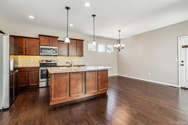 kitchen featuring sink, hanging light fixtures, dark hardwood / wood-style flooring, an island with sink, and stainless steel appliances