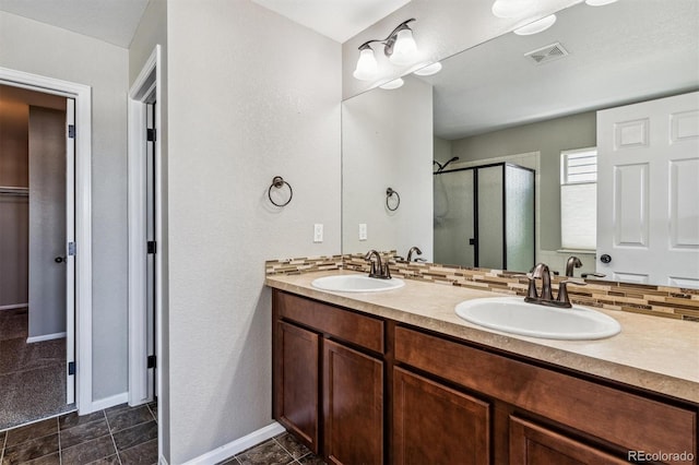 bathroom with an enclosed shower, vanity, and backsplash