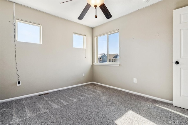 spare room with ceiling fan and carpet