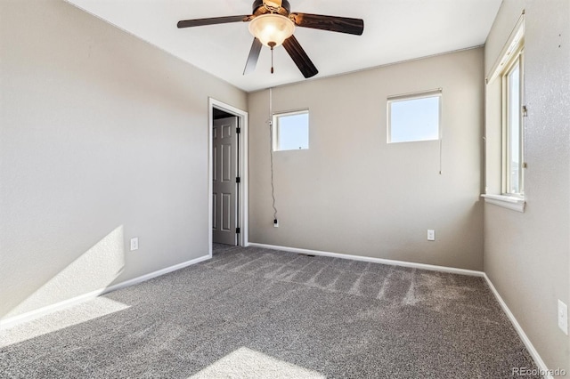 carpeted spare room featuring ceiling fan