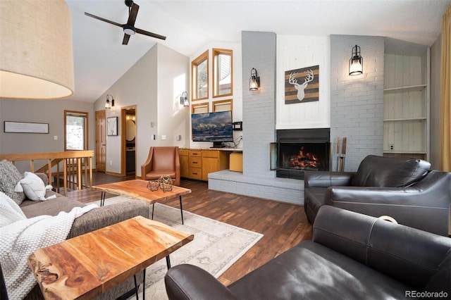 living room featuring ceiling fan, high vaulted ceiling, wood-type flooring, and a brick fireplace