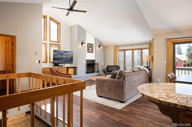 living room with dark hardwood / wood-style flooring, a brick fireplace, a textured ceiling, ceiling fan, and high vaulted ceiling