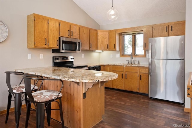 kitchen with decorative light fixtures, kitchen peninsula, a kitchen bar, and appliances with stainless steel finishes