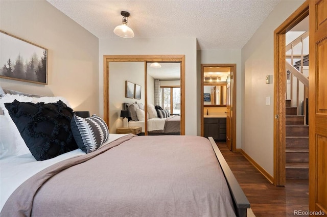 bedroom featuring a textured ceiling, dark hardwood / wood-style floors, a closet, and ensuite bathroom