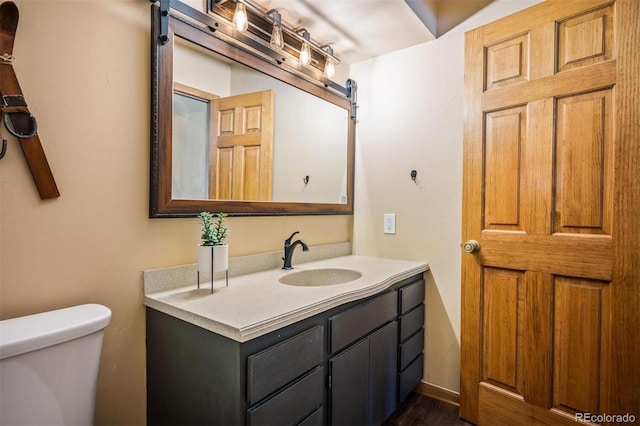 bathroom with hardwood / wood-style flooring, vanity, and toilet