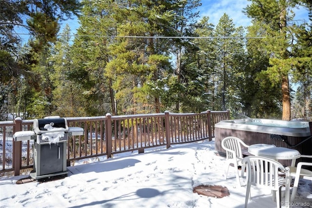 snow covered deck with grilling area and a hot tub