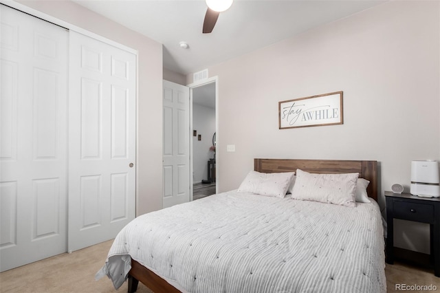 carpeted bedroom with ceiling fan and a closet