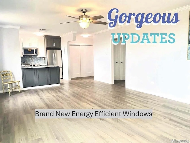 kitchen featuring ornamental molding, stainless steel appliances, light wood finished floors, decorative backsplash, and ceiling fan