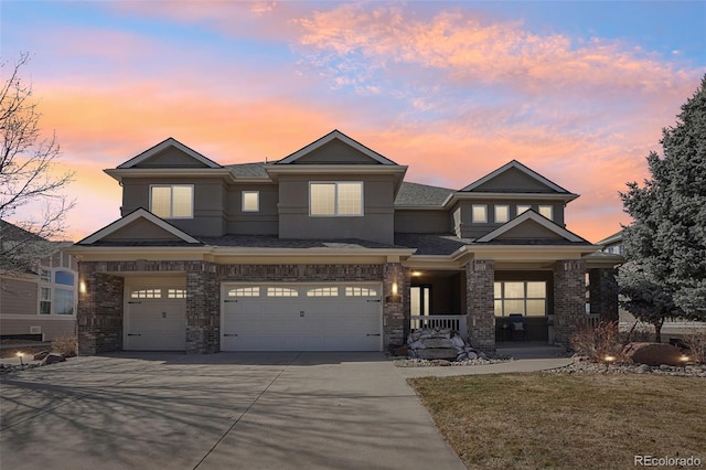 view of front of house featuring a porch, a garage, brick siding, driveway, and stucco siding