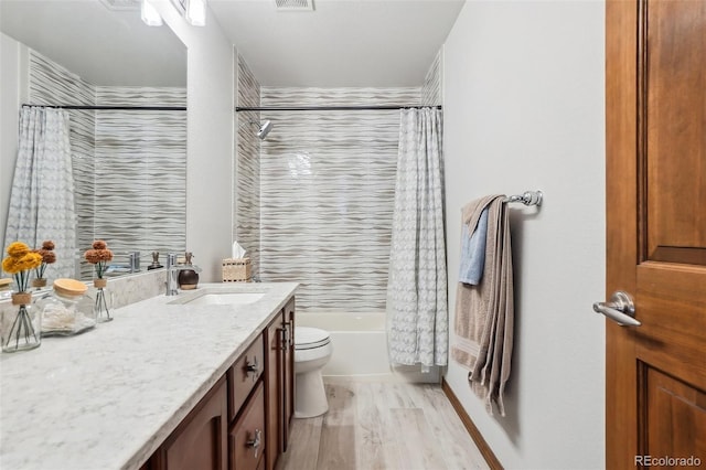 full bathroom featuring shower / tub combo, visible vents, toilet, wood finished floors, and vanity