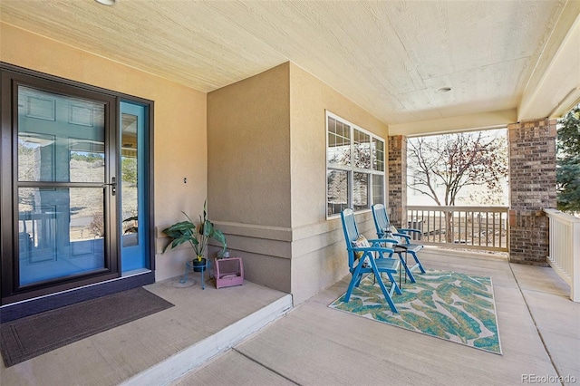 property entrance with a porch and stucco siding