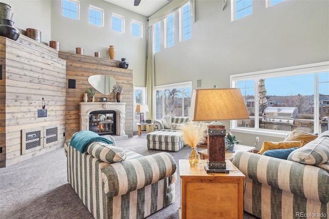 carpeted living area featuring a glass covered fireplace