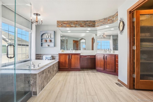 full bathroom featuring a garden tub, wood finished floors, visible vents, a shower stall, and an inviting chandelier