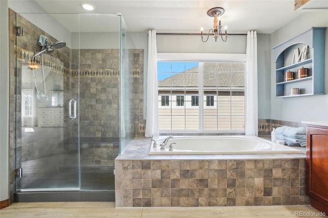 bathroom featuring a garden tub, wood finished floors, a shower stall, and an inviting chandelier