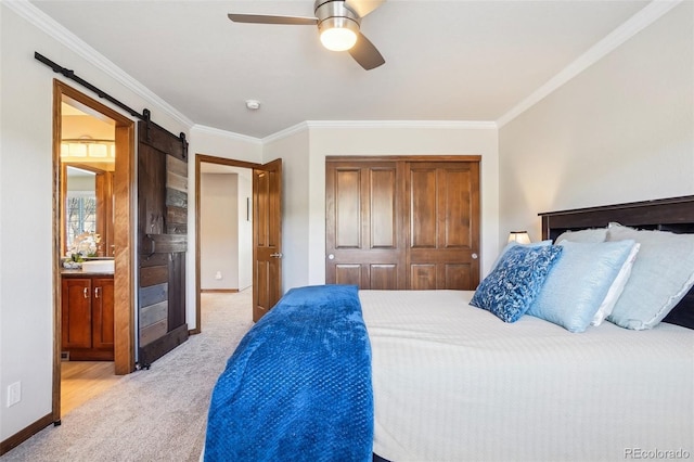 bedroom with a barn door, light carpet, baseboards, a closet, and crown molding