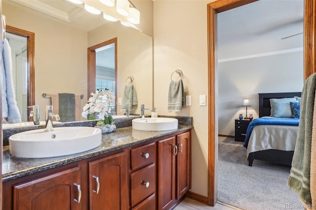 full bath with double vanity, crown molding, connected bathroom, and a sink