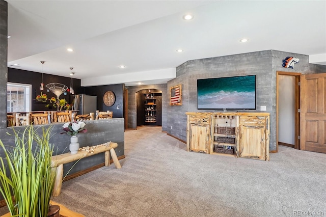 carpeted living room with arched walkways and recessed lighting