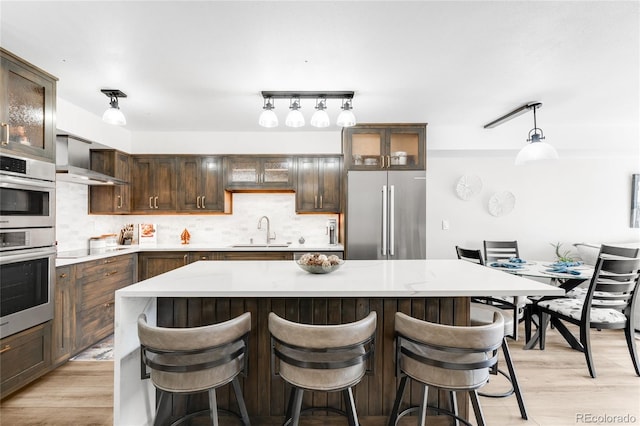 1551 Larimer St Unit 1405, Denver, CO 80202 - kitchen with a sink, stainless steel appliances, backsplash, and light wood-style flooring