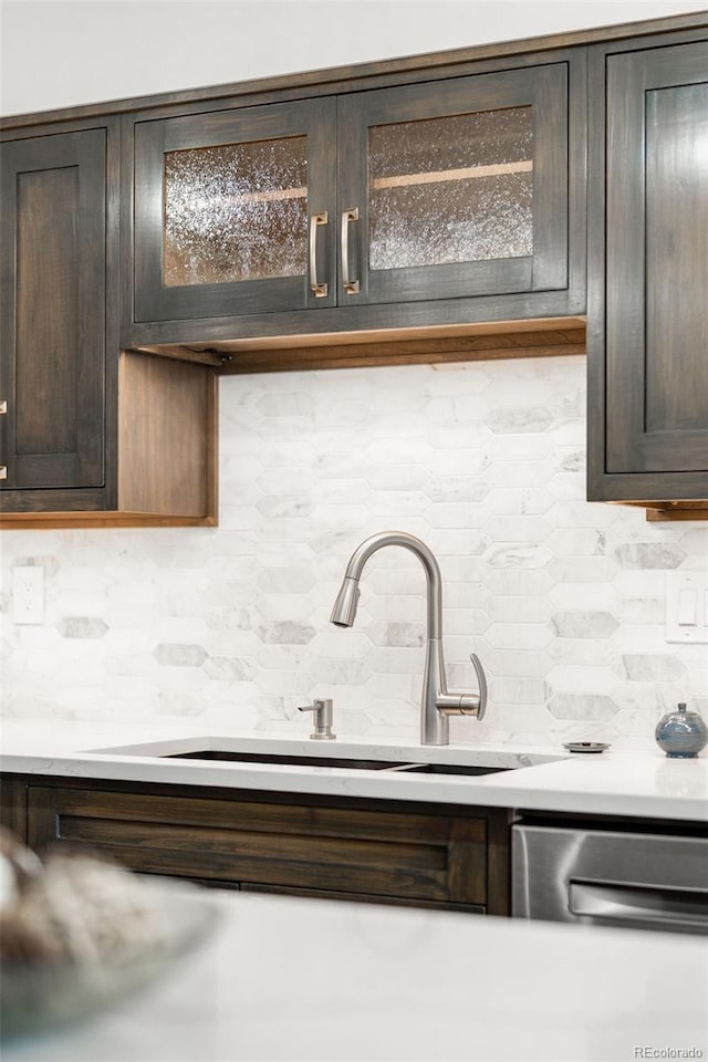 1551 Larimer St Unit 1405, Denver, CO 80202 - kitchen with decorative backsplash, dark brown cabinets, light countertops, and glass insert cabinets