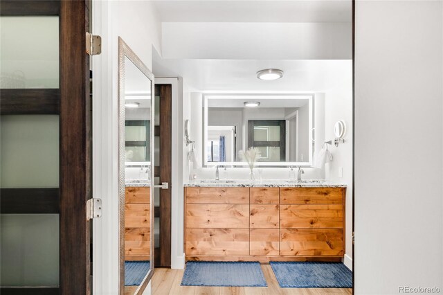 1551 Larimer St Unit 1405, Denver, CO 80202 - full bath featuring double vanity, wood finished floors, and a sink