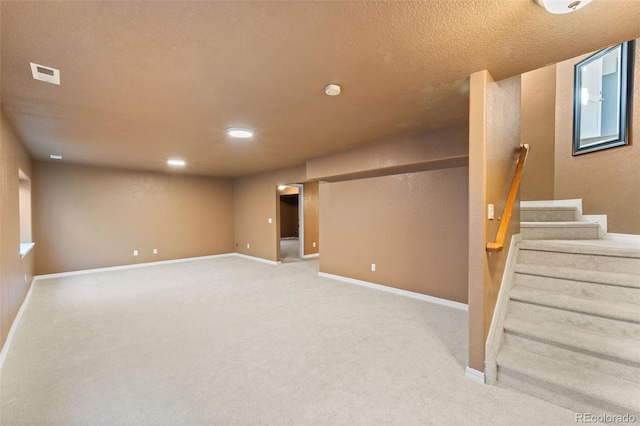 basement featuring a textured ceiling and carpet floors