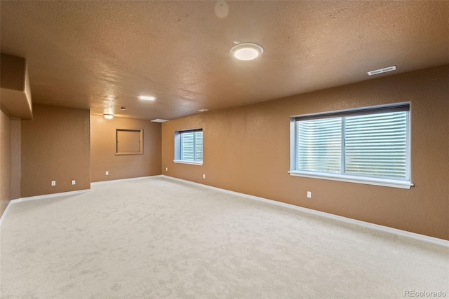 carpeted empty room featuring a textured ceiling