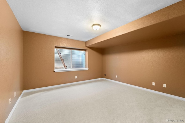 unfurnished room featuring carpet and a textured ceiling