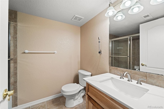 bathroom with tile patterned flooring, an enclosed shower, a textured ceiling, toilet, and vanity