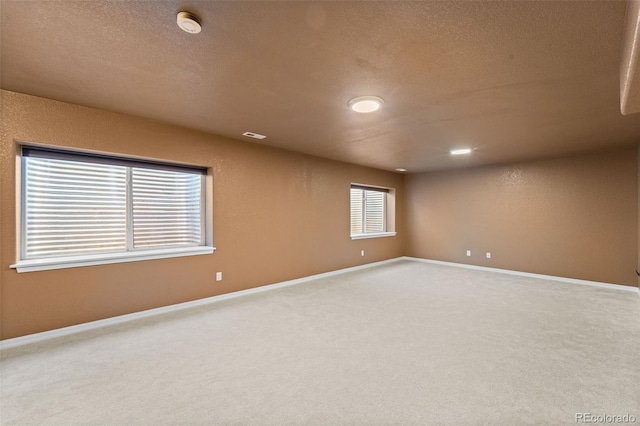 empty room featuring carpet and a textured ceiling