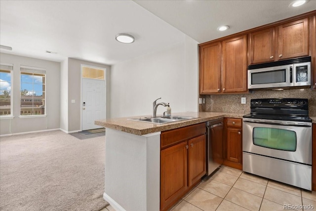 16212 E Geddes Ln Unit 11, Aurora, CO 80016 - kitchen with appliances with stainless steel finishes, a sink, brown cabinets, a peninsula, and light colored carpet