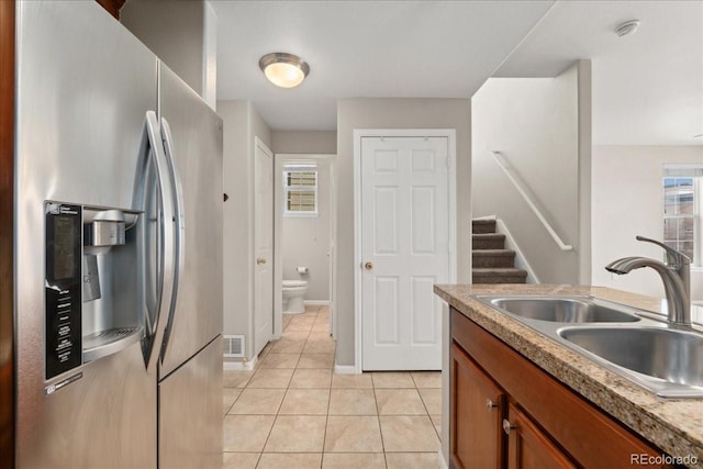 16212 E Geddes Ln Unit 11, Aurora, CO 80016 - kitchen featuring stainless steel refrigerator with ice dispenser, a sink, light tile patterned floors, brown cabinets, and baseboards