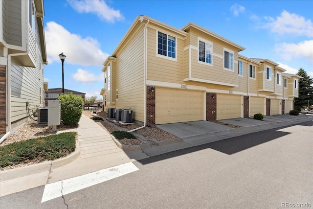 16212 E Geddes Ln Unit 11, Aurora, CO 80016 - view of home's exterior featuring brick siding, an attached garage, central AC, and driveway
