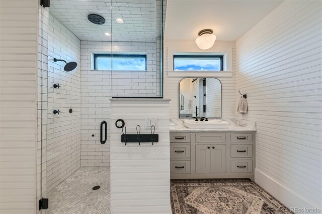 bathroom with vanity, walk in shower, and a wealth of natural light