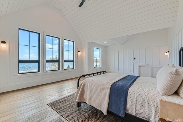 bedroom featuring lofted ceiling, hardwood / wood-style flooring, wood ceiling, and a water view